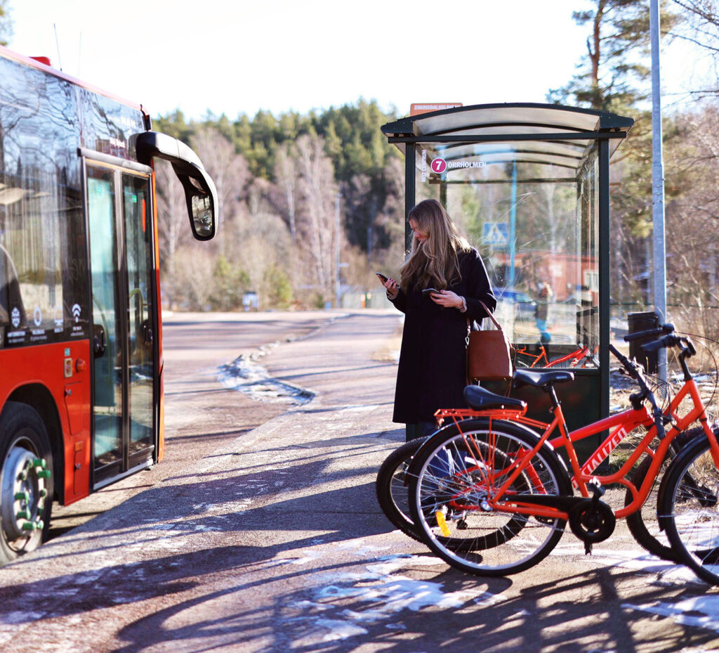 person på busshållplats med buss