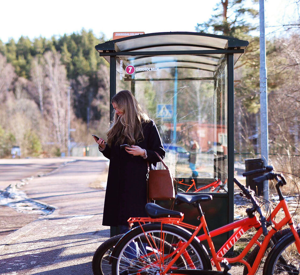 person på busshållplats med buss