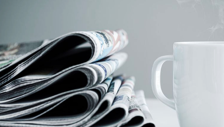 tidningsbunt med kaffekopp